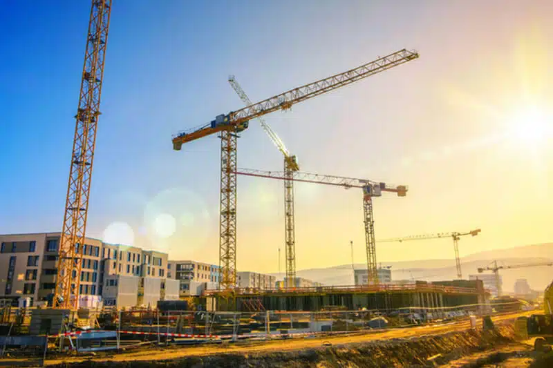 Baukräne auf Baustelle bei Sonnenuntergang