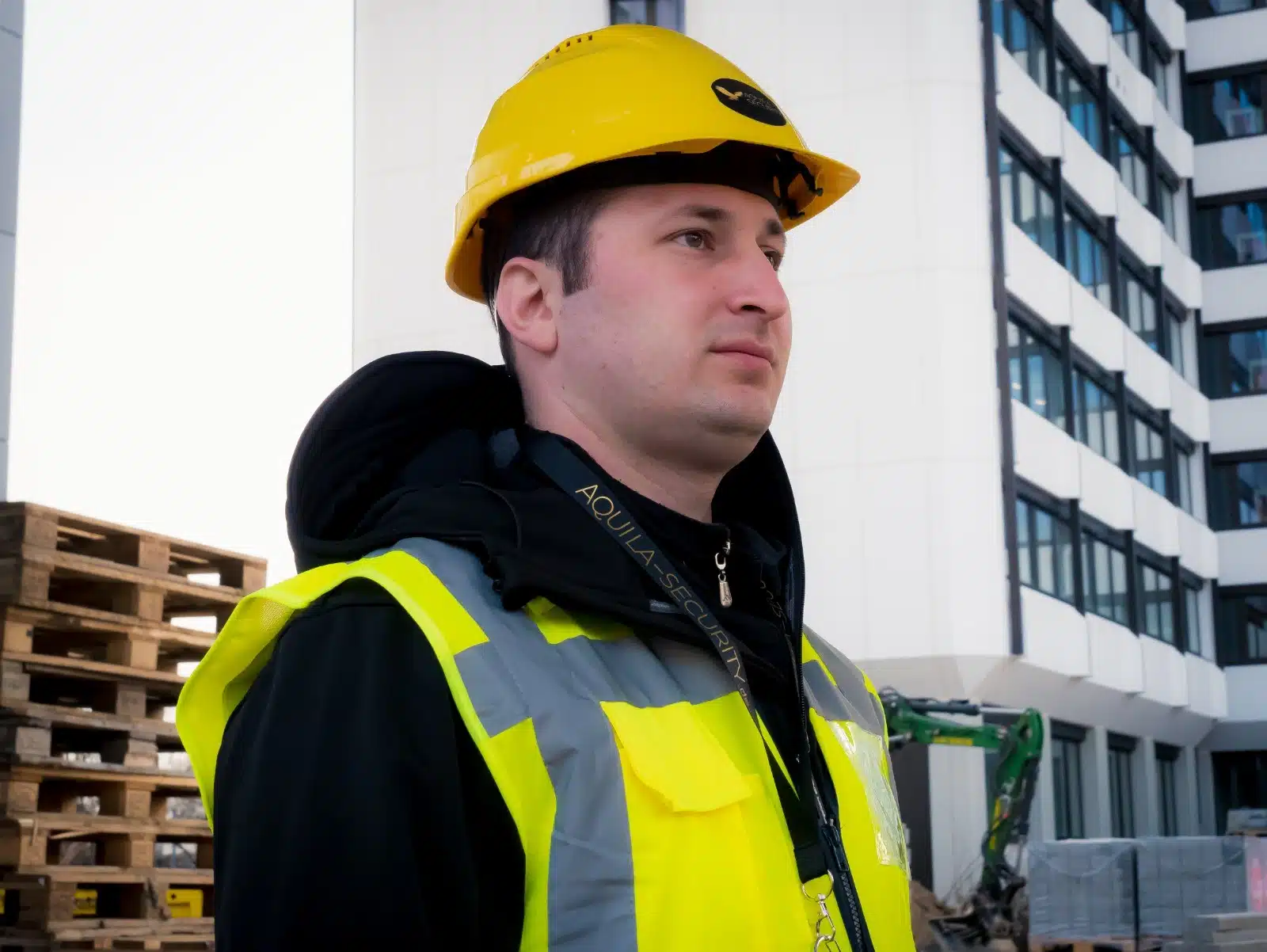 Bauarbeiter mit Helm auf Baustelle vor Gebäude