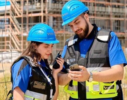 Zwei Bauarbeiter mit Schutzhelmen auf Baustelle