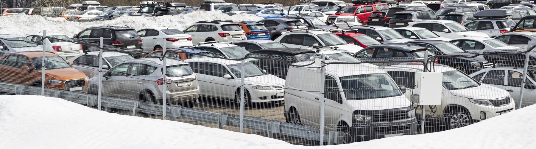 Umzäunter Parkplatz mit abgestellten Fahrzeugen